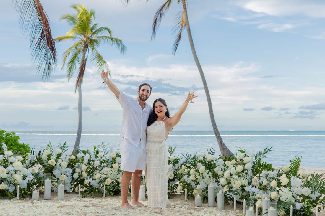Couple celebrating with champagne after a beach marriage proposal in Punta Cana